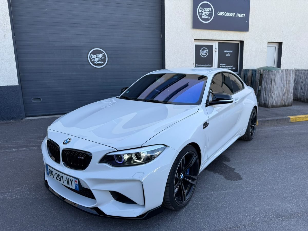 BMW blanche devant le garage Goffart Auto